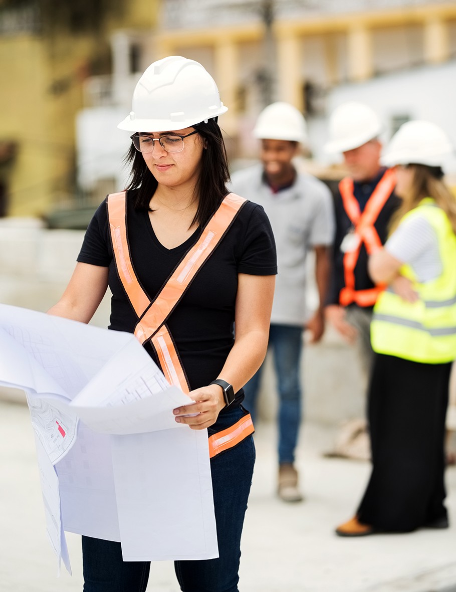 Female construction worker looking at blueprint